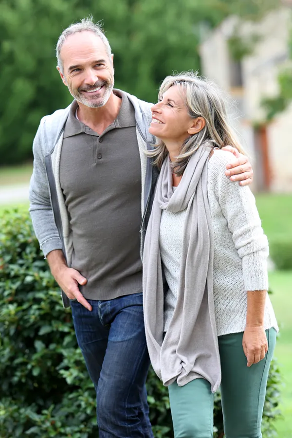 Bioidentical-Hormone-Therapy-Treatment A mature couple in gray toned clothes and jeans walk happily outside, happy with their successful bioidentical hormone treatments from Tanya Zboril, NP of TBT Medical in Halifax.