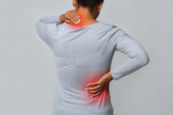 Fibromyalgia-Clinic An image from behind of a woman suffering from Fibromyalgia holding her hands on her neck and lower back. Get fibromyalgia care from Tanya Zboril, NP of TBT Medical in Halifax.