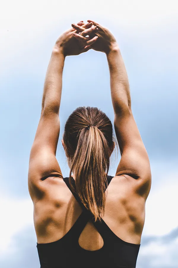 GLP-1-Weight-Loss-Injections-Treatment A toned woman seen from behind stretching her arms into the air. Get GLP-1 Weight Loss Injections from Tanya Zboril, NP of TBT Medical in Halifax.