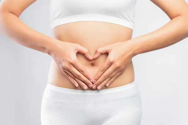 Gut-Microbiome-Therapy-Clinic A woman holds her hands in a heart shape around her gut area. Schedule Targeted Gut Microbiome therapy from Tanya Zboril, NP of TBT Medical in Halifax.