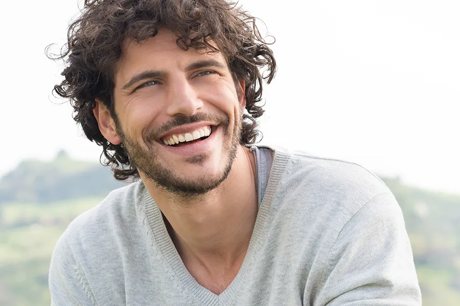 Hair-Loss-Clinic A man with radiant curly hair and a confident smile looks to the horizon. Tanya Zboril, NP of TBT Medical in Halifax offers effective therapies to support hair regrowth and scalp health to treat hair loss.