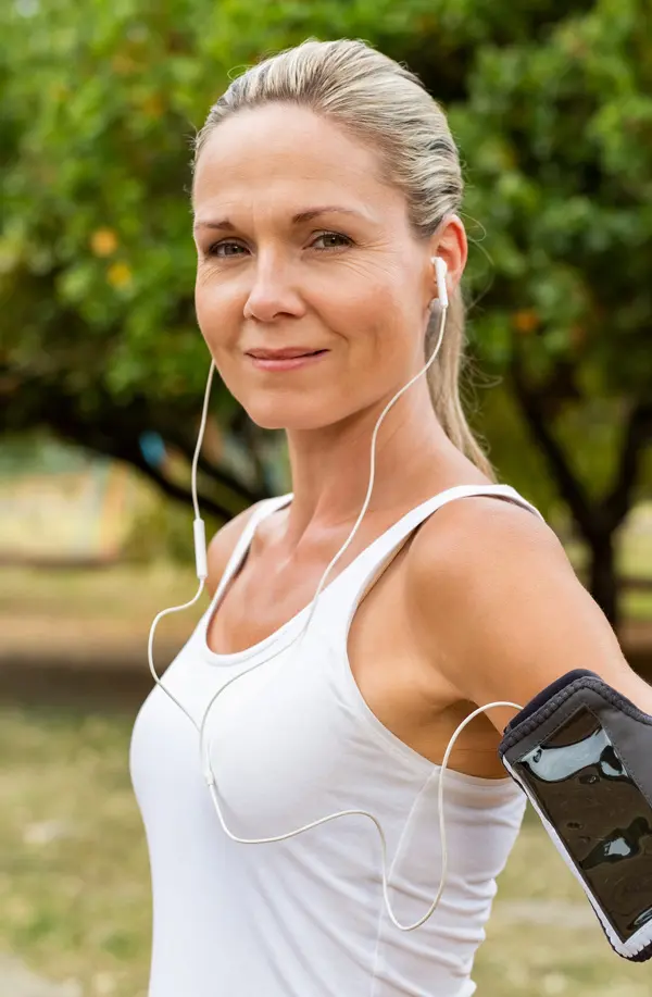 Insulin-Resistance-Treaatment A fit middle aged woman wearing earphones and a tank top smiles after a run. Get insulin resistance treatment from Tanya Zboril, NP of TBT Medical in Halifax.