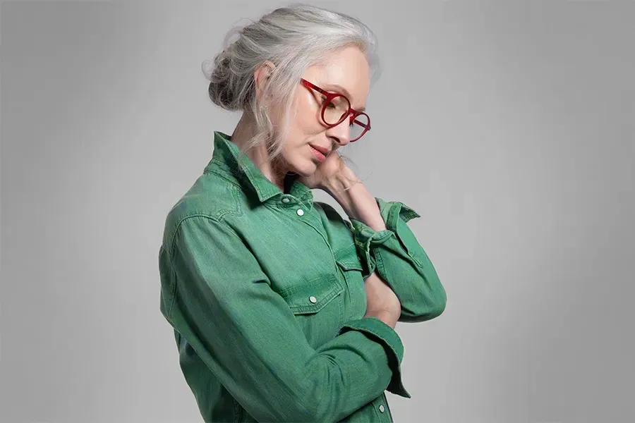 Low-Dose-Naltrexone-Clinic A middle-aged woman in a green shirt holds her neck and grimaces in pain. Schedule low dose naltrexone treatment from Tanya Zboril, NP of TBT Medical in Halifax.