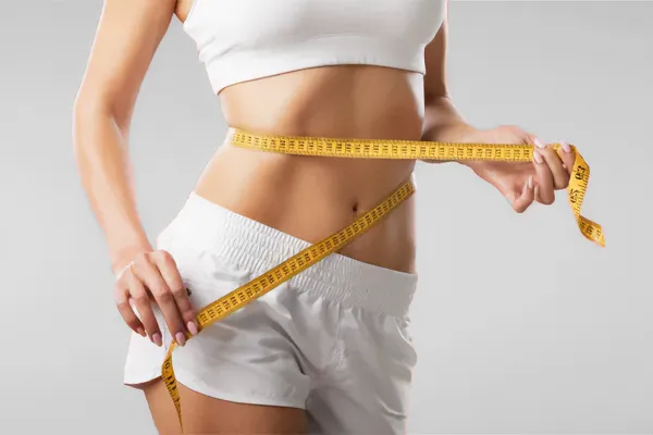 Low-Dose-Naltrexone-for-Weight-Loss-Doctor A woman wraps a measuring tape around her waist to show the success of her Low Dose Naltrexone for Weight Loss treatments from Tanya Zboril, NP of TBT Medical in Halifax.