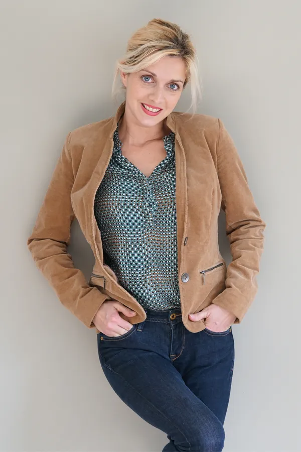 Metabolic-Syndrome-Treatment A smiling blonde woman in a tan leather jacket leans against a gray wall. Schedule metabolic syndrome from Tanya Zboril, NP of TBT Medical in Halifax.