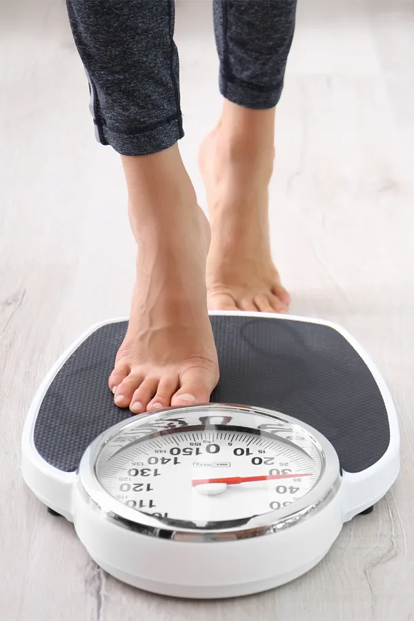 Obesity-Treatment Close up of feet stepping onto a scale. Receive expert functional medicine for obesity treatment by Tanya Zboril, NP of TBT Medical in Halifax.
