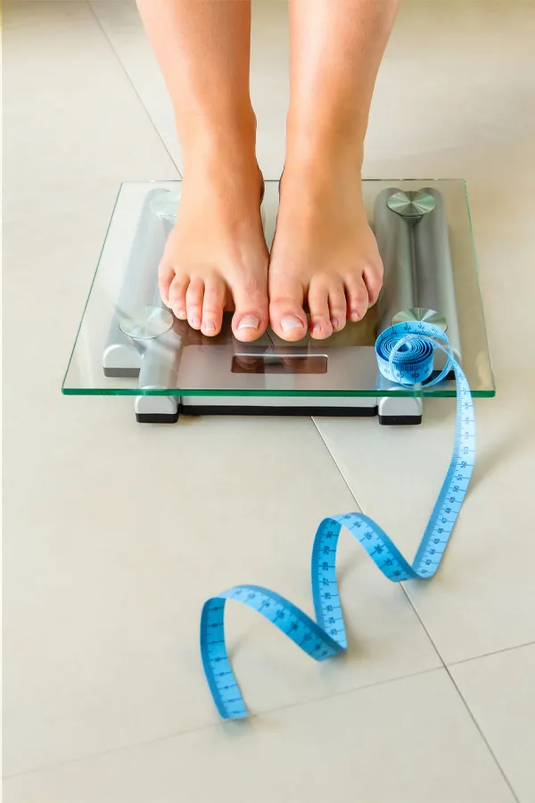 Ozempic-Treatment Feet on a scale with a measuring tape for weight loss. Get Ozempic for weight loss from Tanya Zboril, NP of TBT Medical in Halifax.