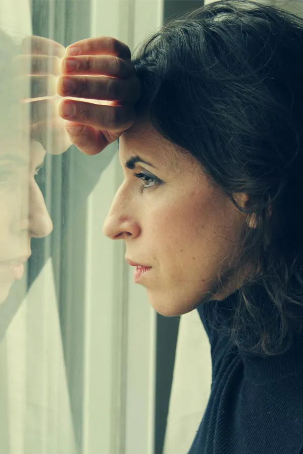 PCOS-Treatment A brunette woman in a thin dark turtleneck looks out the window with a serious expression, suffering from PCOS. Get treatment for Polycistic Ovarian Syndrome/PCOS from Tanya Zboril, NP of TBT Medical in Halifax.