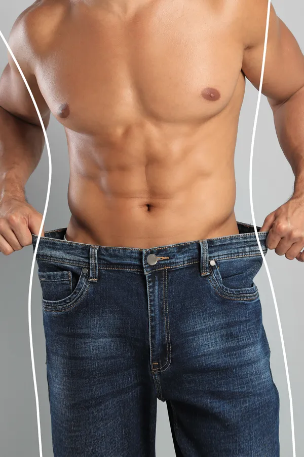 Semaglutide-Weight-Loss-Treatment A strong shirtless man in jeans holds the waistlines of his too-big jeans to show the success of semaglutide weight loss from Tanya Zboril, NP of TBT Medical in Halifax.