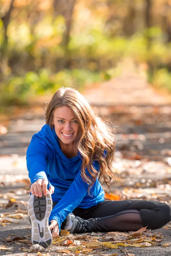 Sermorelin-Treatment A healthy woman in blue sweats stretches on a trail before a run. Get Sermorelin peptide therapy from Tanya Zboril, NP of TBT Medical in Halifax.