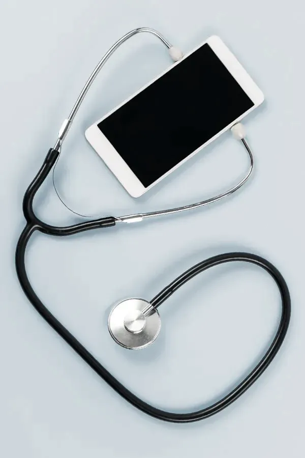 A smartphone with a stethoscope attached to it, symbolizing Telemedicine treatment from Tanya Zboril, NP of TBT Medical in Halifax.