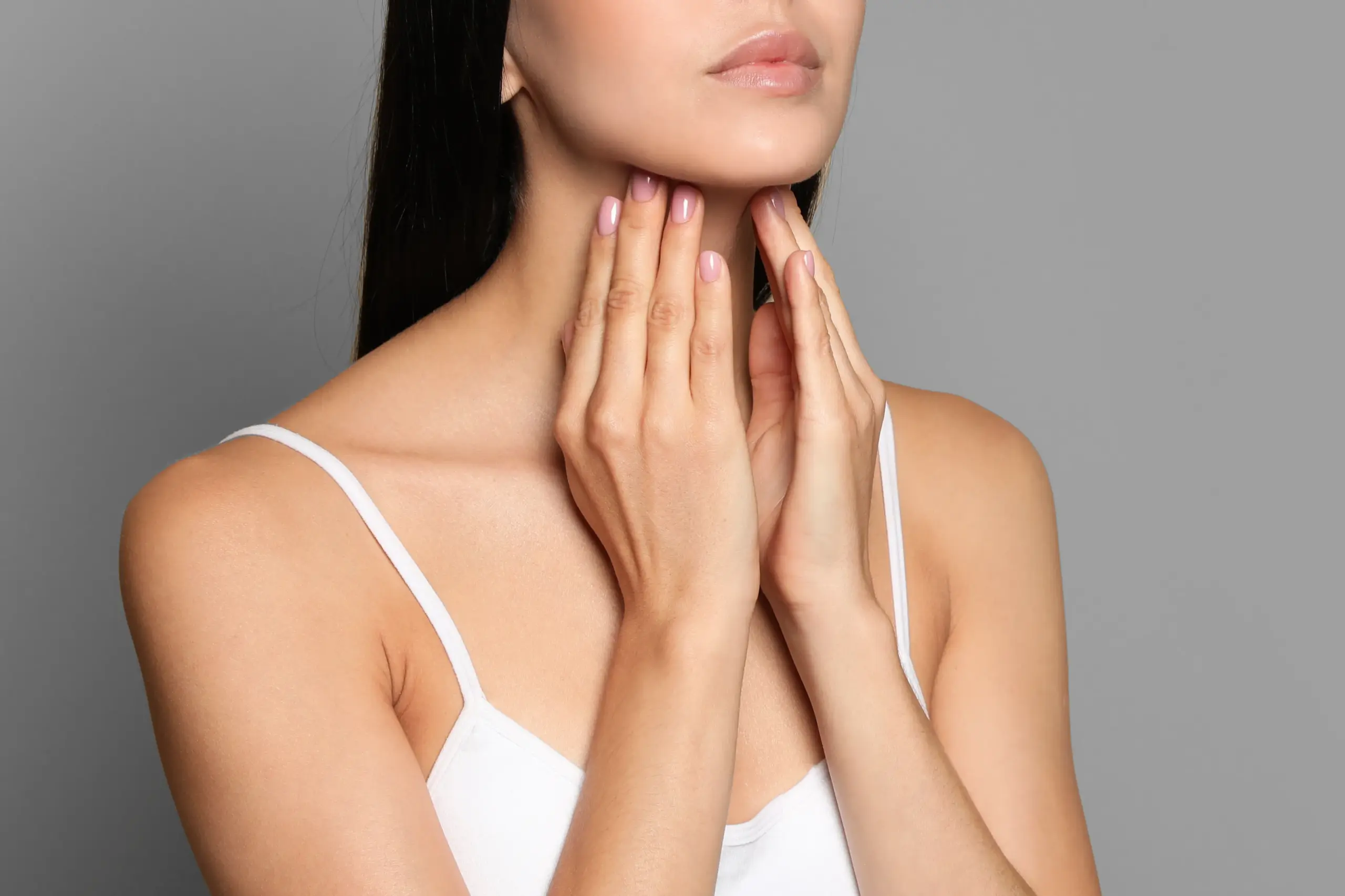 Thyroid-Doctor A woman in a white tank top touches her neck looking for signs of thyroid disorder. Get help for thyroid disorders from Tanya Zboril, NP of TBT Medical in Halifax.