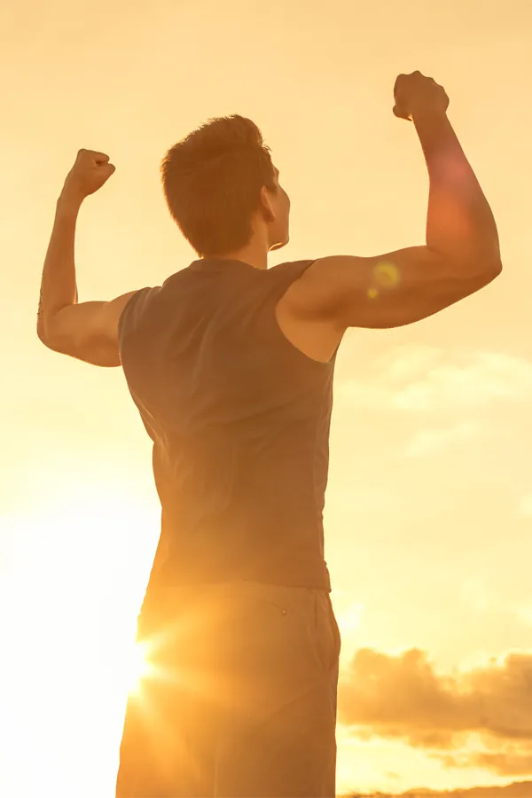 Wegovy-Weight-Loss-Treatment A motivational image of a young man standing with his back to the camera, arms raised triumphantly against a sunrise. Representing Wegovy Weight Loss Injections offered by Tanya Zboril, NP of TBT Medical in Halifax.